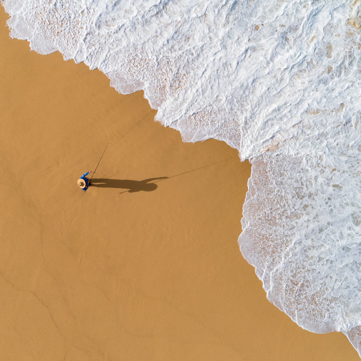 Shore fisherman on the beach seen from above